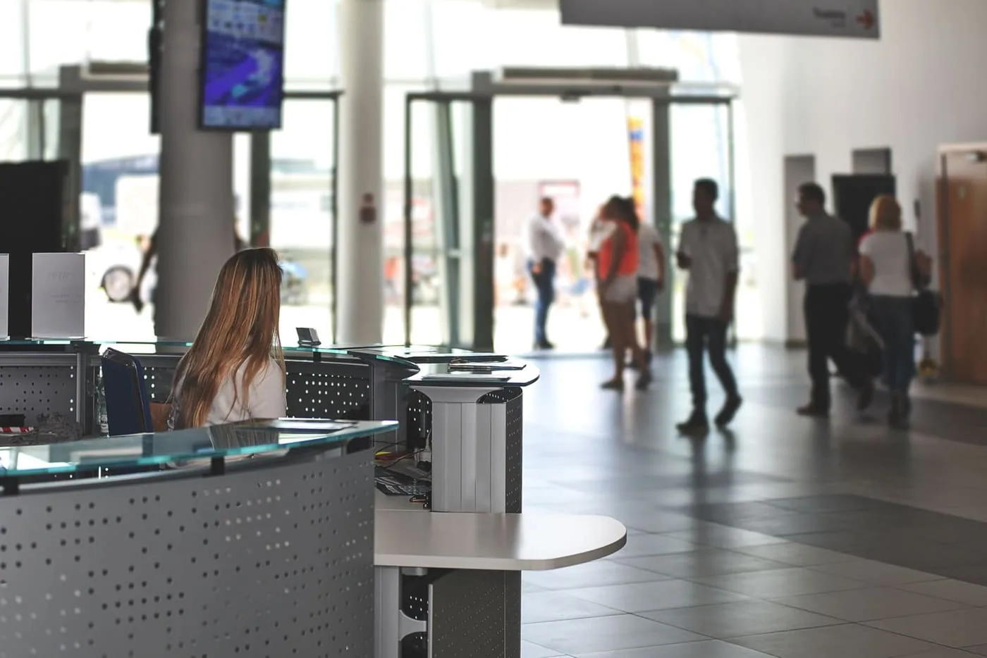 A front-desk team welcoming visitors in a busy lobby